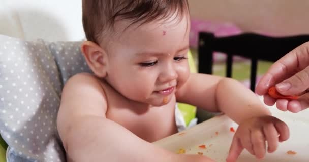 Mam voedt de jongen met een lepel en hand, familie eten en ouderschap concept. eerste aanvullende levensmiddelen en zelfvoeding — Stockvideo