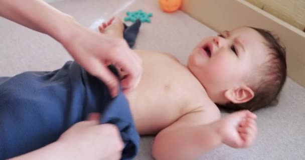 Mama ubiera małego chłopca na łóżku. Medycyna, opieka zdrowotna, rodzina, niewinność, pediatria, koncepcje szczęśliwego niemowlęcia — Wideo stockowe