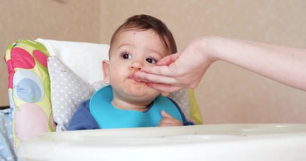 Máma krmí chlapce lžící a rukou, rodinným jídlem a rodičovstvím. první doplňková jídla a vlastní krmení — Stock video