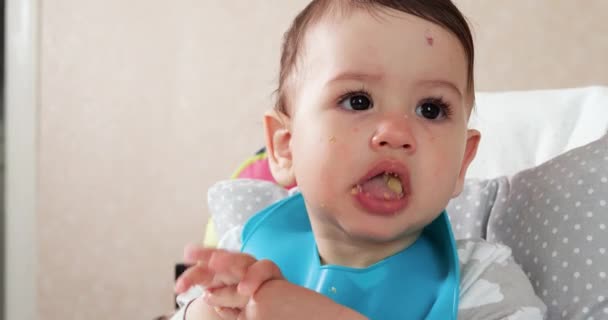 Mamãe alimenta o menino com uma colher e mão, comida familiar e conceito de paternidade. primeiros alimentos complementares e auto-alimentação — Vídeo de Stock