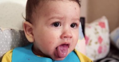 Anne çocuğu kaşıkla ve elle besler, aile yemeği ve ebeveynlik konseptiyle. İlk tamamlayıcı gıda ve kendini besleme.