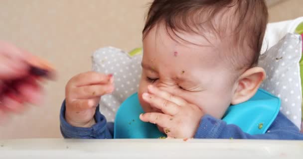 ママは子供にスプーンと手、家族の食べ物と親の概念を与えます。最初の補完的な食品や自食は — ストック動画