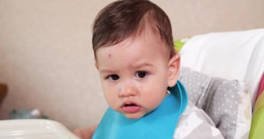 Anne çocuğu kaşıkla ve elle besler, aile yemeği ve ebeveynlik konseptiyle. İlk tamamlayıcı gıda ve kendini besleme.