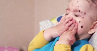 Anne çocuğu kaşıkla ve elle besler, aile yemeği ve ebeveynlik konseptiyle. İlk tamamlayıcı gıda ve kendini besleme.