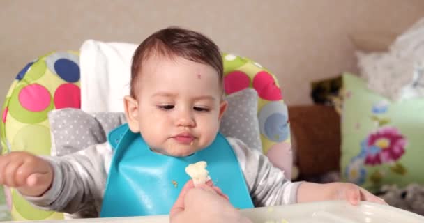 Mam voedt de jongen met een lepel en hand, familie eten en ouderschap concept. eerste aanvullende levensmiddelen en zelfvoeding — Stockvideo