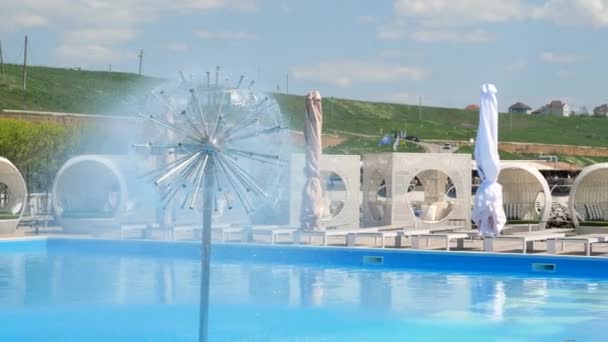 Letni ośrodek wypoczynkowy z luksusowym leżakiem i fontanną pod osłoną słońca, w letni dzień — Wideo stockowe