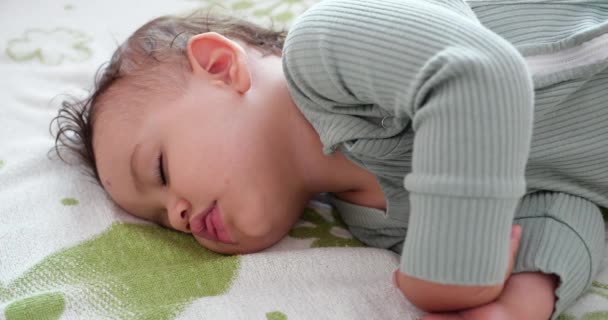 Yatakta uyuyan tatlı bir erkek bebek. Huzurlu bir erkek çocuk bir odada yatakta uyuyor. Yumuşak odaklanma. Uyuyan bebek konsepti. Bir yaşındaki çocuk evde uyuyor. — Stok video