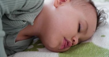 Yatakta uyuyan tatlı bir erkek bebek. Huzurlu bir erkek çocuk bir odada yatakta uyuyor. Yumuşak odaklanma. Uyuyan bebek konsepti. Bir yaşındaki çocuk evde uyuyor.