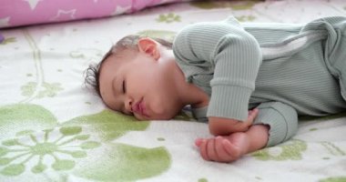 Yatakta uyuyan tatlı bir erkek bebek. Huzurlu bir erkek çocuk bir odada yatakta uyuyor. Yumuşak odaklanma. Uyuyan bebek konsepti. Bir yaşındaki çocuk evde uyuyor.