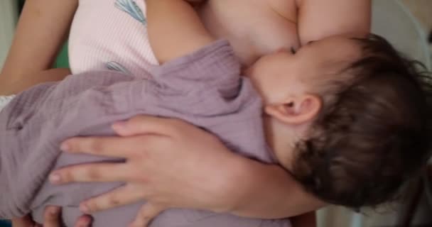 Egy kisgyerek békésen alszik az anyák mellkasán. Anya a karjaiban rázza a babát. — Stock videók