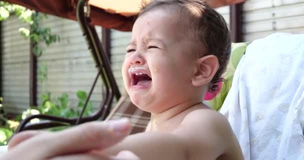 Retrato de un niño que se sienta en una silla infantil. El niño feliz bebe leche, kéfir o productos lácteos de una taza. Nutrición correcta y natural para niños — Vídeos de Stock