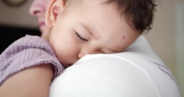 Ett litet barn somnade i sina fäders armar. Pappa gungar barnet för att sova hemma. närbild — Stockvideo