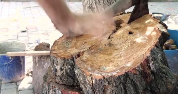 Резка дерева с большим острым топором, человек рубит дрова, рубка дерева на деревянном бревне летом в доме — стоковое видео