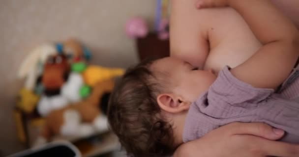 Маленький ребенок мирно спит на груди матери. Мама трясет ребенка на руках — стоковое видео