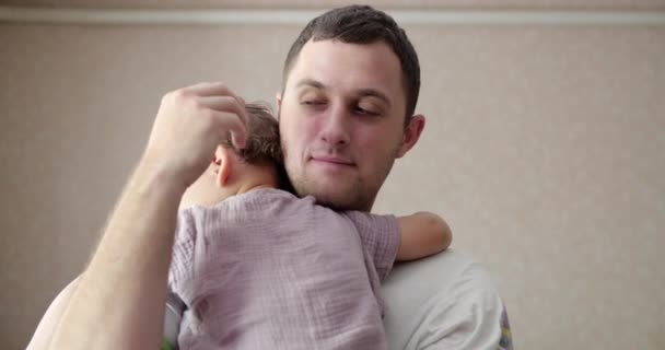 Egy kisbaba elaludt az apja karjaiban. Apa ringatja a babát, hogy otthon aludjon. közelkép — Stock videók