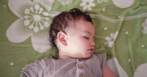Sevimli küçük çocuk tatlı tatlı uyuyor ve yatak odasında uyurken renkli rüyalar görüyor. — Stok video