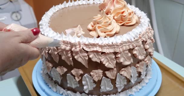 Mujer pastelera está vertiendo crema en la torta de esponja utilizando la bolsa de pastelería, vista de cerca. El chef de pastelería está cocinando pastel casero. cocinar, hornear y cocinar, cocinar en casa — Vídeo de stock