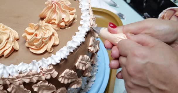 Mujer pastelera está vertiendo crema en la torta de esponja utilizando la bolsa de pastelería, vista de cerca. El chef de pastelería está cocinando pastel casero. cocinar, hornear y cocinar, cocinar en casa — Vídeo de stock