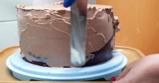 Confiseur femme est la crème à tartiner sur les côtés du gâteau à l'aide de spatule, vue rapprochée. concept culinaire, de cuisson et de cuisson des aliments, cuisine maison — Video