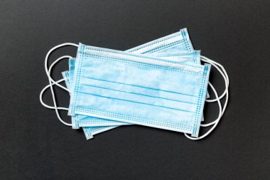 Renkli arka plandaki tıbbi maske yığınına yazılan virüs salgınını kapat. Wuhan virüsü. Dünya salgını.