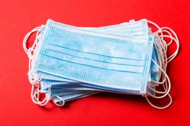 Renkli arka plandaki tıbbi maske yığınına yazılan virüs salgınını kapat. Wuhan virüsü. Dünya salgını.