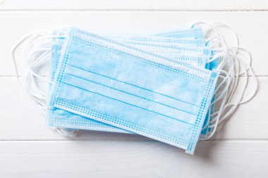 Renkli arka plandaki tıbbi maske yığınına yazılan virüs salgınını kapat. Wuhan virüsü. Dünya salgını.