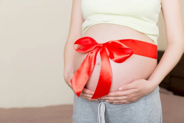 Belly Gravid Kvinna Bunden Med Röd Rosett Ett Hem Bakgrund — Stockfoto