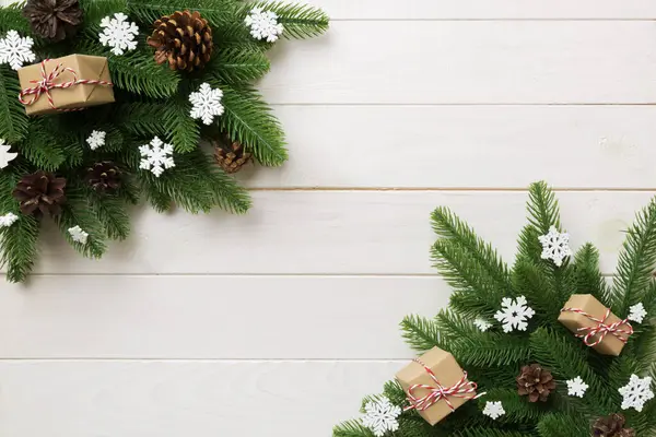 Noel süslemeleri, köknar ağacı dalları ve hediye kutusundaki karanlık masa. Kopyalama alanı olan üst görünüm çerçevesi.