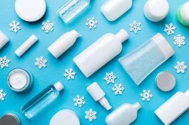 Makyaj ürünleri ve renkli arka planda Noel süsleri. Üst Görünüm Yeni Yıl Güzellik Konsepti.