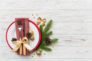 Noel süsleri, tabaklar, inekler, çatallar ve kaşıklarla Noel sofrası. Noel tatili geçmişi. Kopyalama alanı olan üst görünüm.