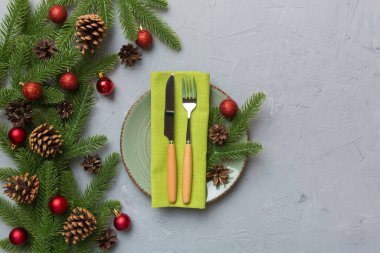 Noel süsleri, tabaklar, inekler, çatallar ve kaşıklarla Noel sofrası. Noel tatili geçmişi. Üst görünüm.