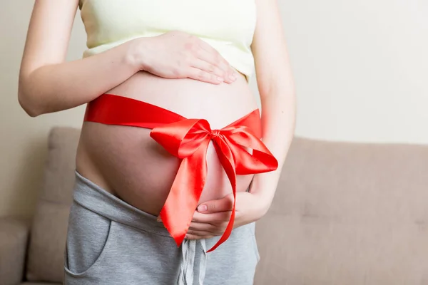 Belly Gravid Kvinna Bunden Med Röd Rosett Ett Hem Bakgrund — Stockfoto
