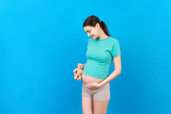 Mujer Embarazada Feliz Sosteniendo Oso Peluche Contra Vientre Fondo Color —  Fotos de Stock