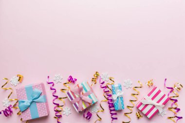 Renkli kağıda sarılı ve renkli arka planda konfetiyle süslenmiş hediye kutularıyla tatil dairesi yatıyordu. Noel, Doğum günü, Sevgililer Günü ve satış konsepti, üst manzara.