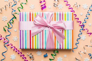 Noel kompozisyonu. Renkli arka planda yeni yıl süslemeleri olan hediye kutusu. Noel, kış, yeni yıl konsepti. Düz konum, üst görünüm, kopyalama alanı.