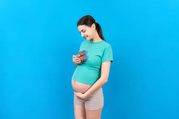 Mujer Embarazada Feliz Mostrando Botas Pequeñas Para Niño Fondo Color —  Fotos de Stock