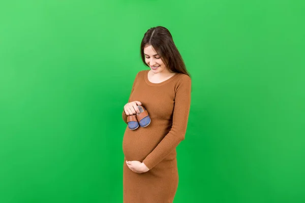 Glückliche Schwangere Frau Zeigt Kleine Stiefel Für Einen Kleinen Jungen — Stockfoto