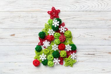 Renkli arka planda renkli el yapımı top dekorasyonundan yapılmış Noel ağacı, yukarıdan görünüyor. Kopya alanı ile yeni yıl konsepti.