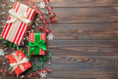 Renkli kağıda sarılı ve renkli arka planda konfetiyle süslenmiş hediye kutularıyla tatil dairesi yatıyordu. Noel, Doğum günü, Sevgililer Günü ve satış konsepti, üst manzara.