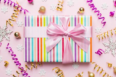 Noel kompozisyonu. Renkli arka planda yeni yıl süslemeleri olan hediye kutusu. Noel, kış, yeni yıl konsepti. Düz konum, üst görünüm, kopyalama alanı.