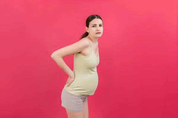 Mulher Grávida Com Uma Dor Nas Costas Fundo Colorido Isolado — Fotografia de Stock