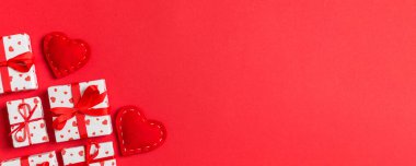 Renkli arka planda hediye kutularının ve kırmızı tekstil kalplerinin tatil kompozisyonu ve tasarımınız için boş alan. Sevgililer Günü konseptinin en üst görüntüsü.