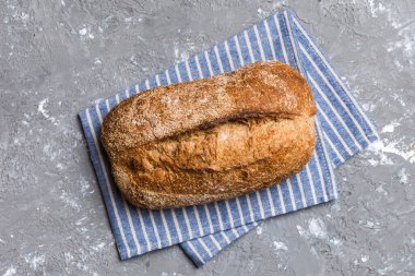 Taze ev yapımı tam buğday ekmeği. Peçetedeki ekmek kırsal arka planda, taze ekmek üst görünümü.