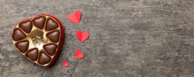 Sevgililer Günü için kırmızı kutuda lezzetli çikolatalı pralinler. Kalp şeklinde çikolata kutusu, fotokopi alanı ile üst görünüm..