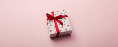 Mercan arka planda kırmızı kurdele ve kalp ile hediye kutusu, metin için kopya alanı ile üst görünüm.