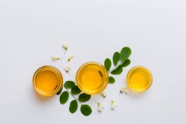 Akasya çiçekli ve yapraklı bal kavanozu. Taze bal üst görünüm düz yatıyordu.