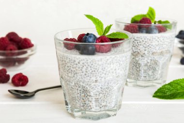 Sağlıklı kahvaltı ya da sabah chia tohumlu vanilyalı puding ahududu ve böğürtlen, vejetaryen gıda, diyet ve sağlık konsepti. Ahududu ve yabanmersinli Chia pudingi..