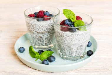 Sağlıklı kahvaltı ya da sabah chia tohumlu vanilyalı puding ahududu ve böğürtlen, vejetaryen gıda, diyet ve sağlık konsepti. Ahududu ve yabanmersinli Chia pudingi..