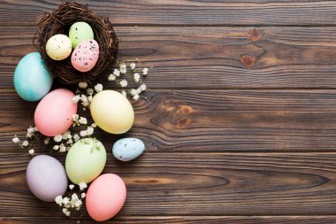Mutlu Paskalya kompozisyonu. Paskalya yumurtaları renkli masada, çingeneyle birlikte. Doğal boyalı renkli yumurtalar arkaplan arkaplan görünümü kopya alanı ile.