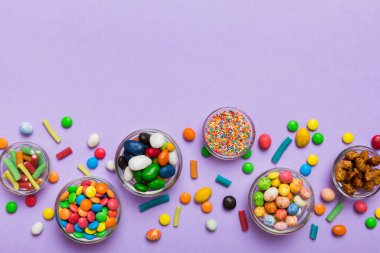 farklı renkte yuvarlak şekerler ve kavanozlar. Fotokopi alanı olan büyük çeşitlilikteki şeker ve şekerlerin üst görünümü.